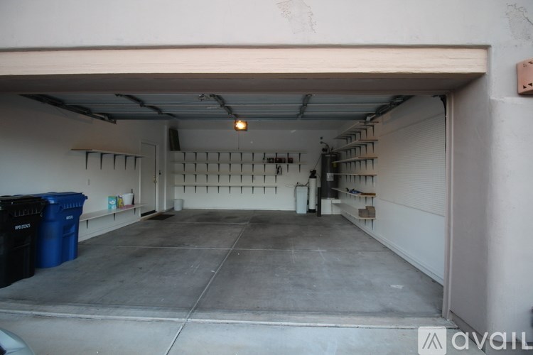 A large garage with a concrete floor and a white wall.