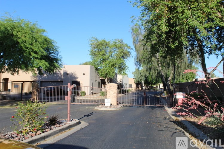 A gated entrance to a building with a red sign on a post.