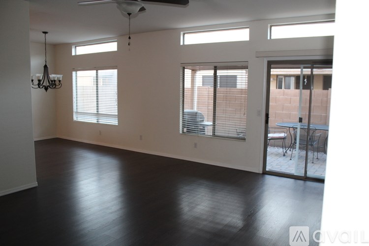 A spacious room with a ceiling fan and sliding glass doors.