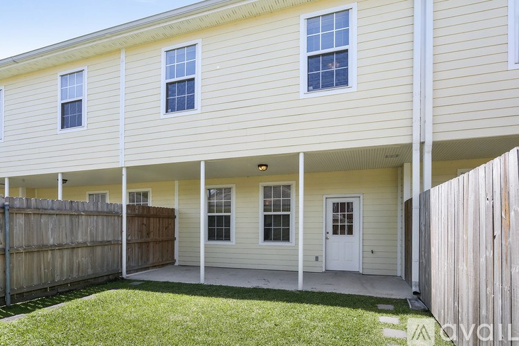 A yellow house with a white door and windows.