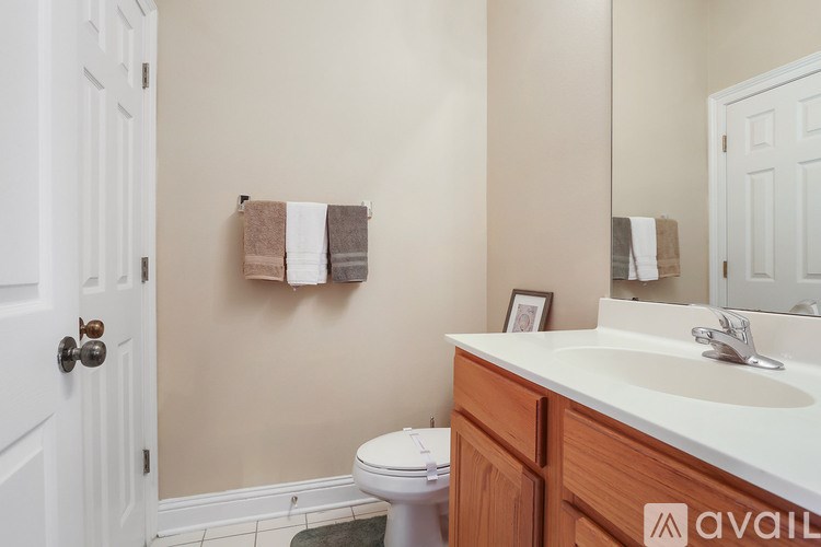 A bathroom with a toilet, sink, and towel rack.