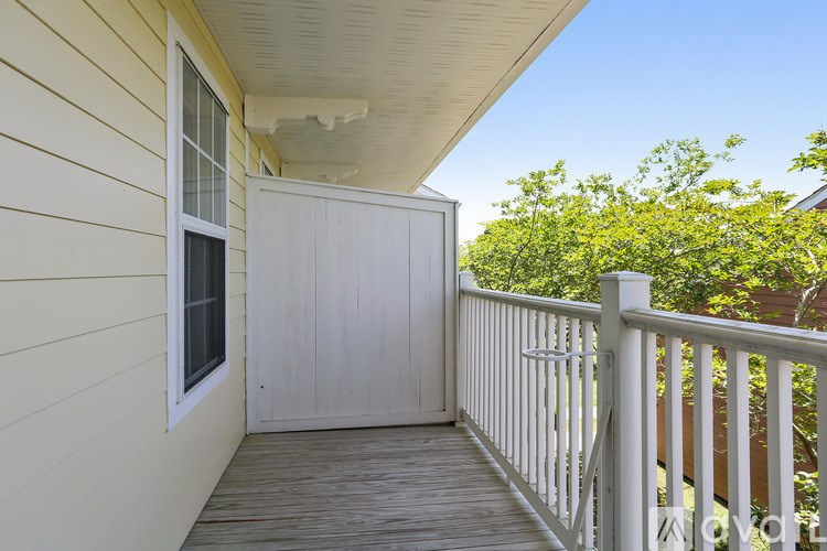A white door is on the porch of a house.