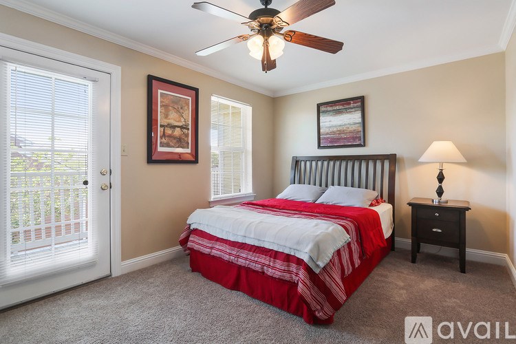 A bedroom with a bed, nightstand, and a ceiling fan.
