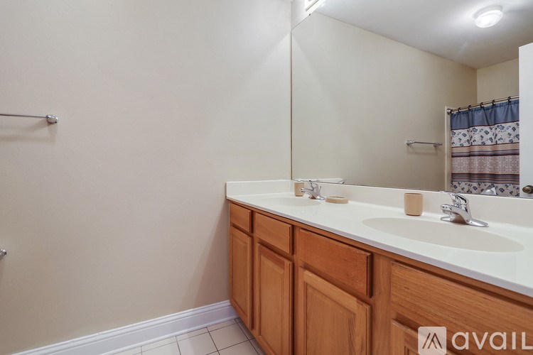 A bathroom with a white counter and wooden cabinets.