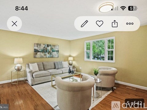 A living room with a beige sofa, a coffee table, and a painting on the wall.