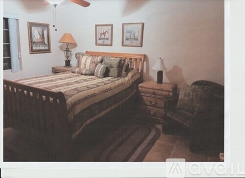 A bedroom with a bed, nightstand, and lamp.