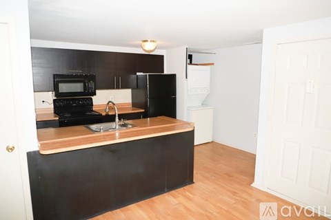 A kitchen with black appliances and wooden countertops.