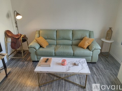 A living room with a green couch and a white coffee table.
