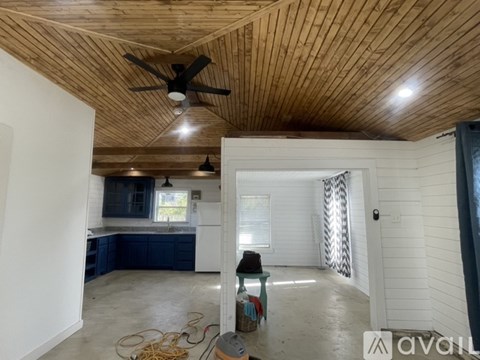 A room with a wooden ceiling and a fan in the middle.