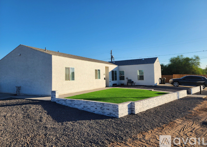 A modern house with a white exterior and a green lawn in front.