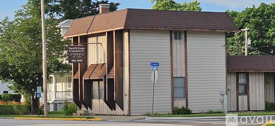 A two-story building with a brown roof and a sign on the front.