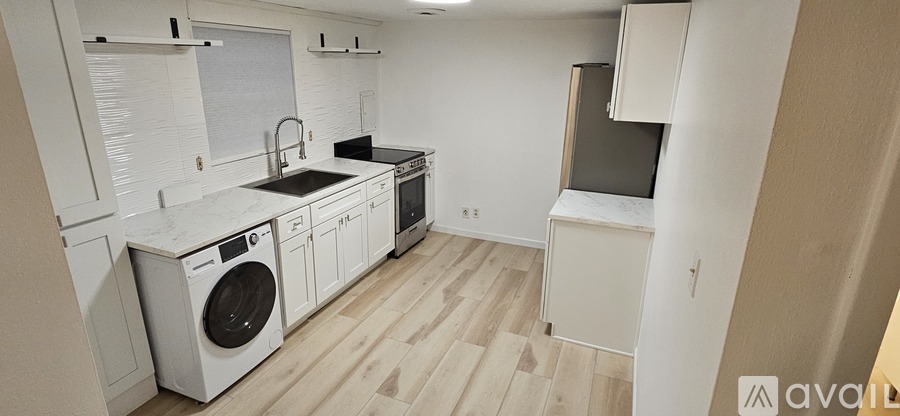 A room with wooden flooring and a doorway leading to another room.