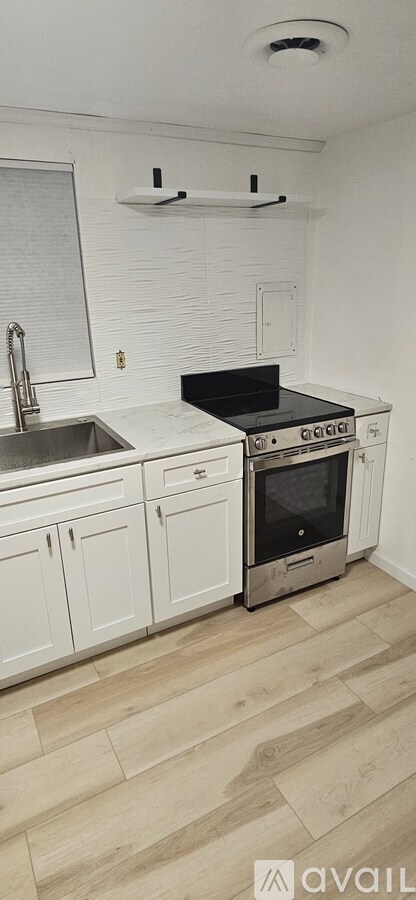 A kitchen with wooden floors and white appliances.