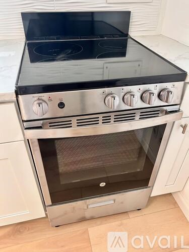 A stainless steel oven with a black top is installed in a kitchen.