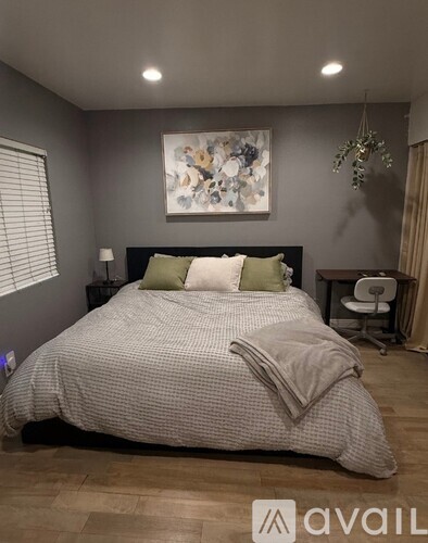 A modern bedroom with a large bed and a small nightstand.