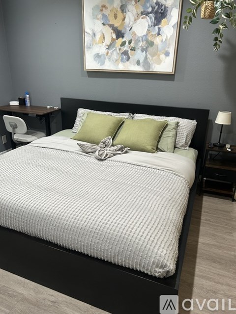 A modern bedroom with a large bed and a small nightstand.