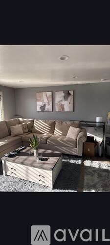 A modern living room with a large sectional sofa and a wooden coffee table.