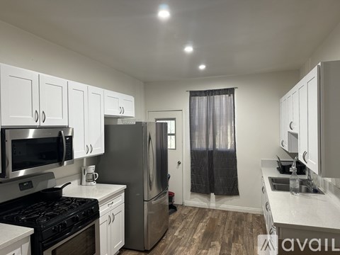 A kitchen with a stove, refrigerator, and microwave.