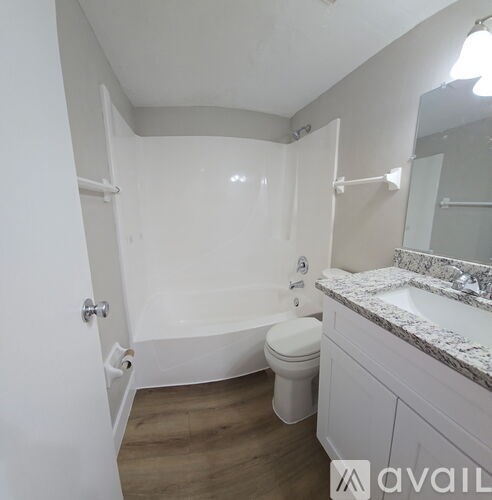 A white bathroom with a toilet, sink, and bathtub.