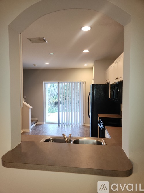 A kitchen with a sink and a refrigerator.