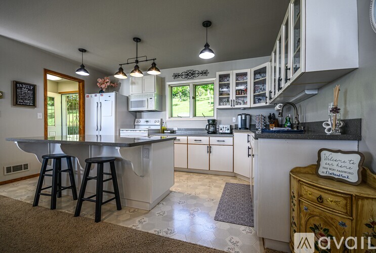 A kitchen with a table and bar stools.