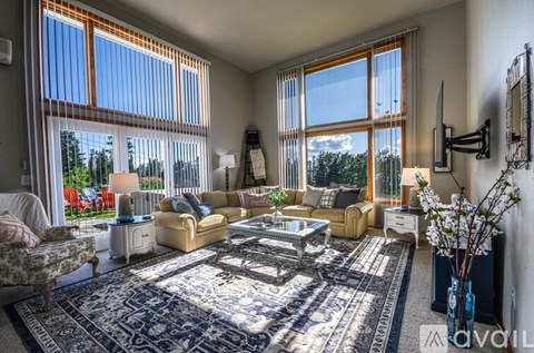 A living room with a sofa set, a coffee table, and a rug.
