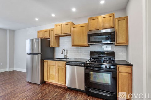 A kitchen with wooden cabinets and black appliances.