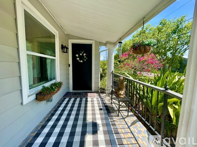 A black door with a wreath on it is the focal point of this image.