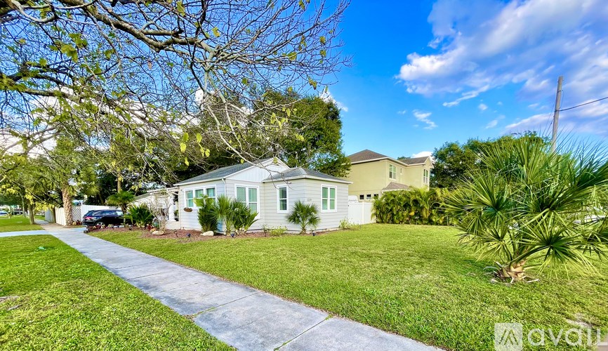 A house with a white fence and a green lawn.