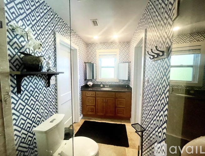 A bathroom with a toilet, sink, and mirror.