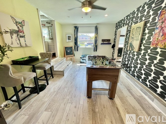 A living room with a pool table and a dining table.