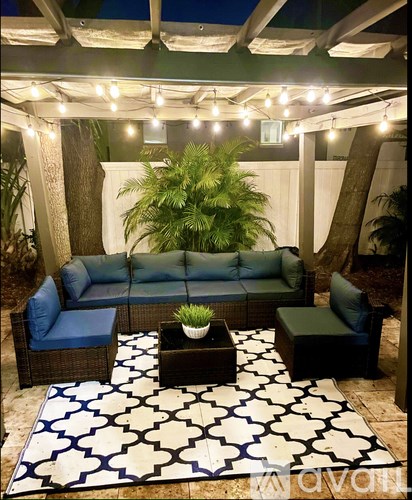 A patio with a couch, table, and lights.