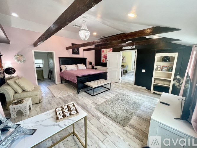 A bedroom with a bed, a chair, and a coffee table.