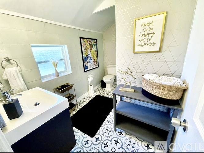 A bathroom with a white sink and a black and white tiled floor.
