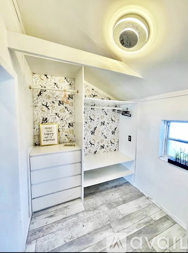 A bathroom with a white towel rack and a window.