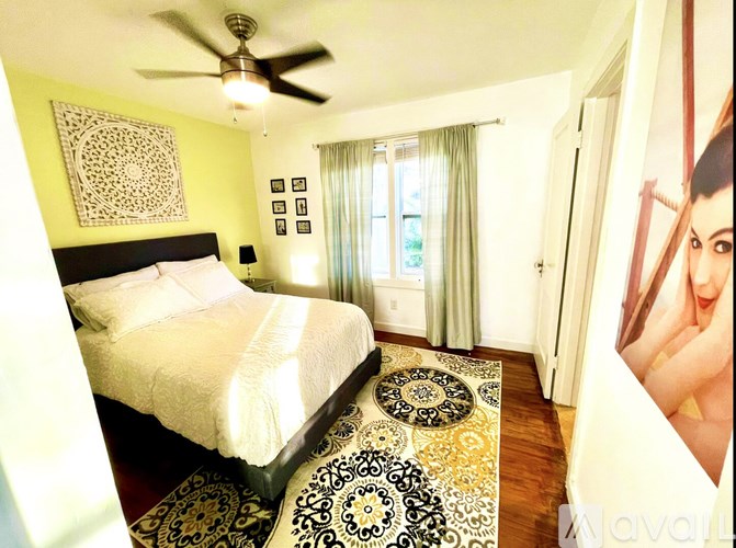 A bedroom with a bed, a ceiling fan, and a rug.