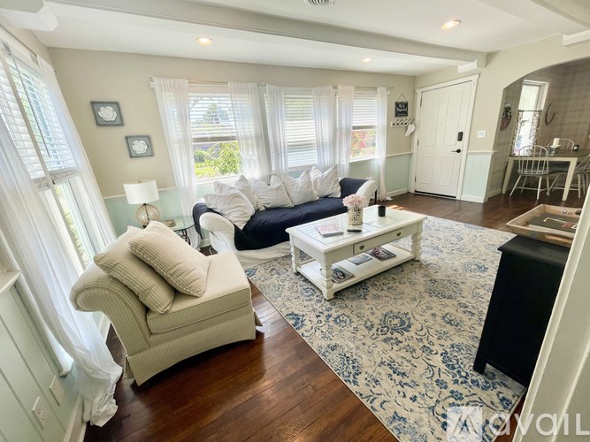 A living room with a sofa, armchair, and coffee table.