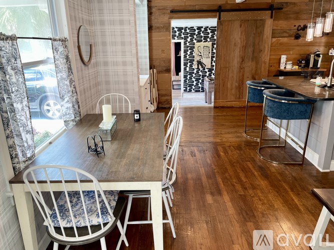 A dining room with a wooden table and chairs.
