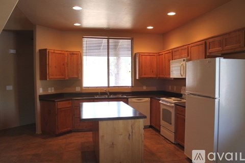 A kitchen with wooden cabinets and a white refrigerator.