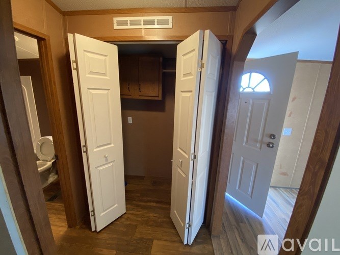 A room with a toilet and a cabinet is visible through an open door.