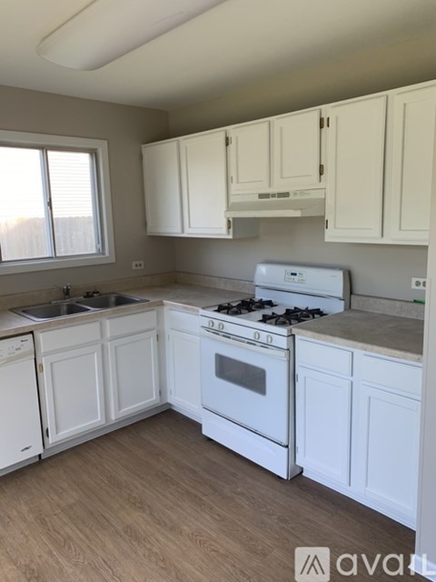 A kitchen with white cabinets and appliances.