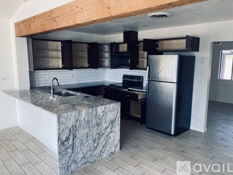 A kitchen with a marble countertop and stainless steel appliances.