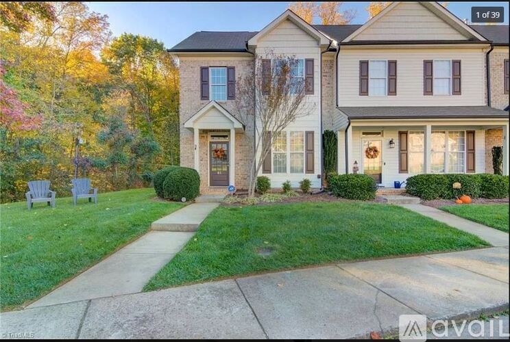 A house with a front yard and a sidewalk in front of it.