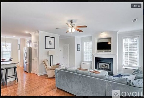 A living room with a grey couch and a fireplace.