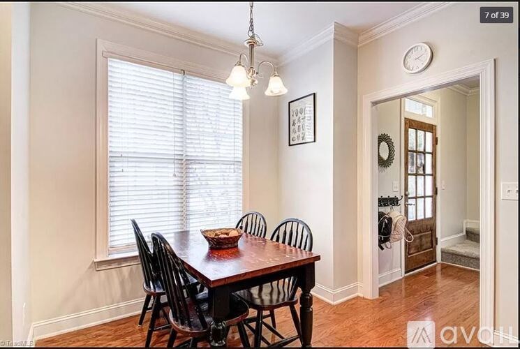 A dining room with a wooden table and chairs.