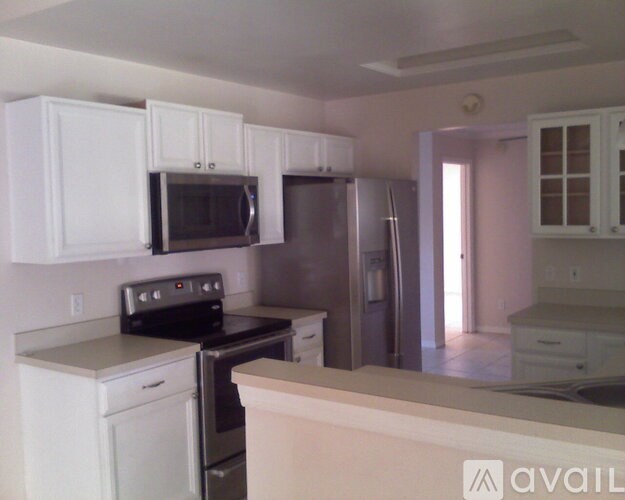 A kitchen with white cabinets and appliances.