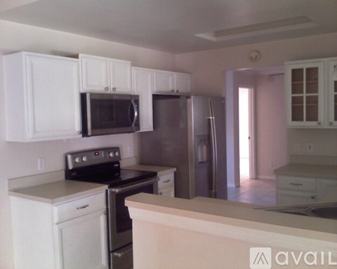 A kitchen with white cabinets and appliances.
