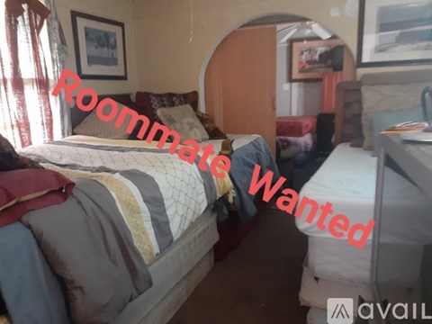 A bedroom with a bed, a desk, and a chair is available for rent.