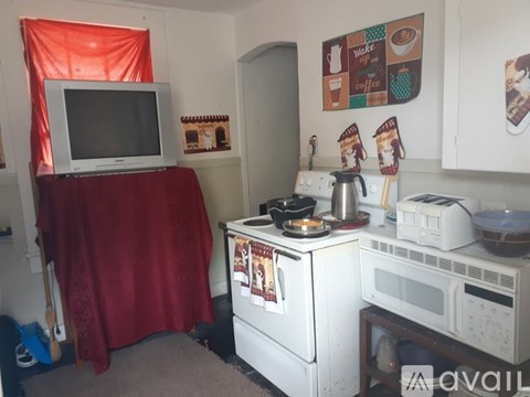 A small kitchen with a white stove top oven and microwave.