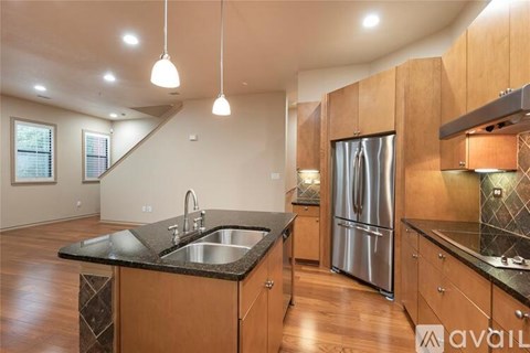 A kitchen with wooden cabinets and a stainless steel refrigerator.